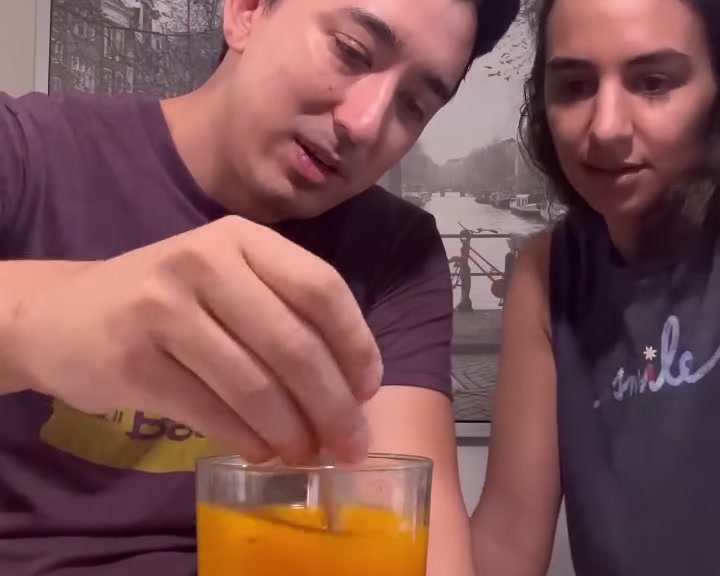 Me stirring the first powder version of Mighty into water while Laila watches