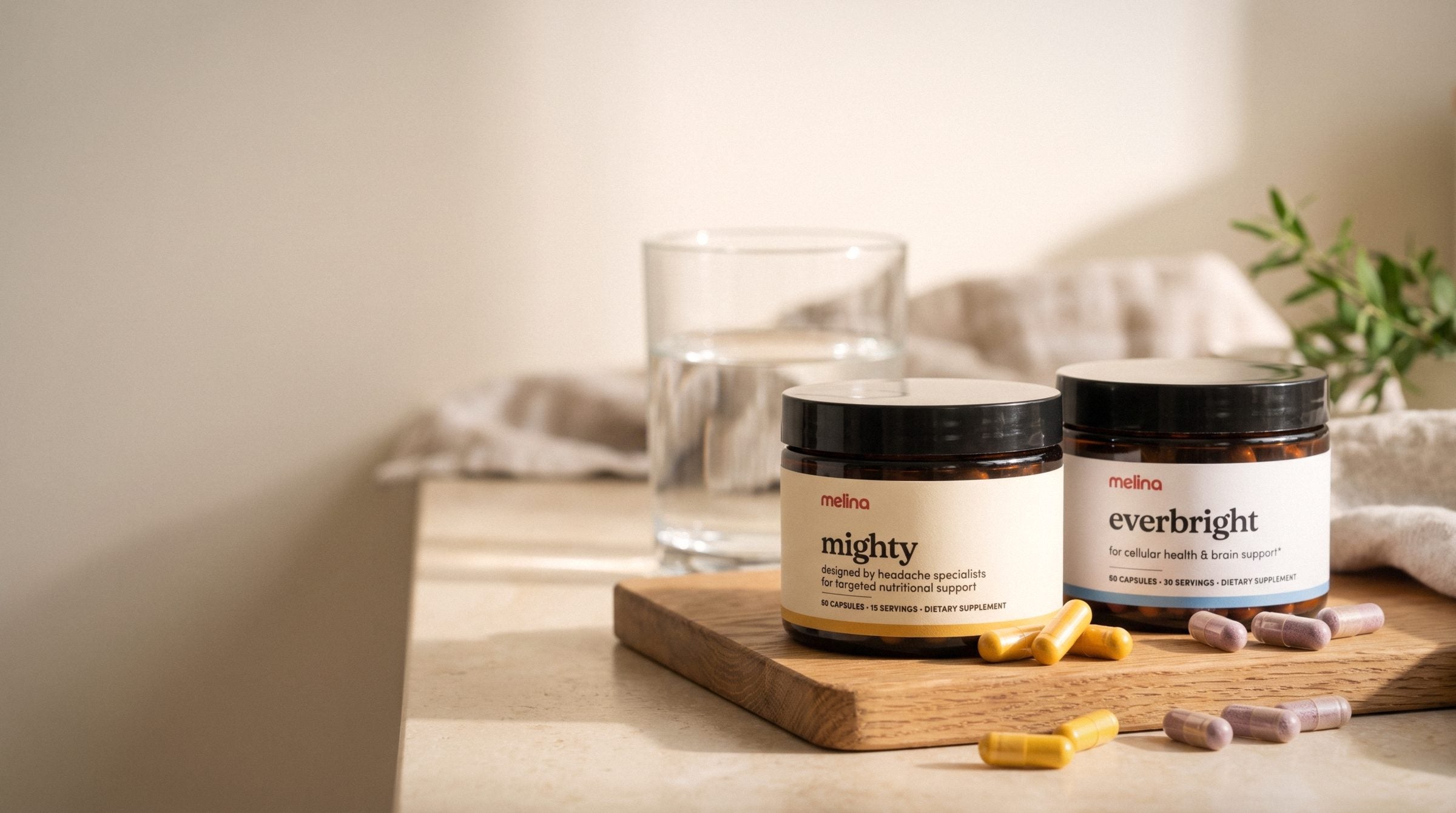 Mighty and Everbright jars on a sunlit kitchen counter with their capsules and a glass of water