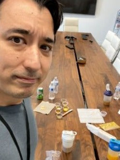 Jeremy at a table covered with capsule samples during formula testing